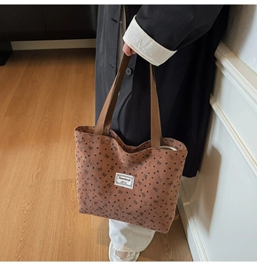 Détail du grand sac cabas en velours côtelé marron avec motifs cœurs et étiquette textile