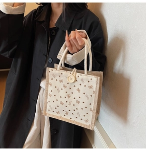 Détail du sac en lin avec imprimé nœud, fermeture à bouton et anse en corde tressée