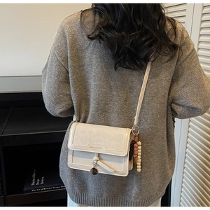 Sac bandoulière avec rabat léopard et détail de perles porté par un mannequin