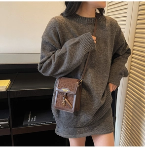 Close-up of leopard print phone bag worn cross-body over a grey knit dress