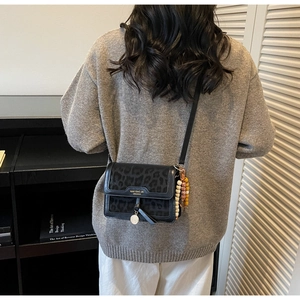 Sac bandoulière noir imprimé léopard chic avec breloques en métal et pendentif perlé