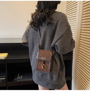 Detail view of leopard print crossbody bag with leather panel and logo on model