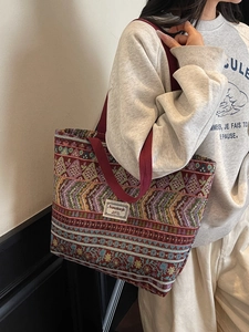 Ethnic style jacquard tote bag with geometric pattern and sturdy handles on model