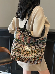 Ethnic bohemian tote bag with colorful woven patterns and black shoulder strap on model
