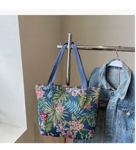 Detail of tropical floral jacquard canvas tote bag with palm leaves and hibiscus patterns