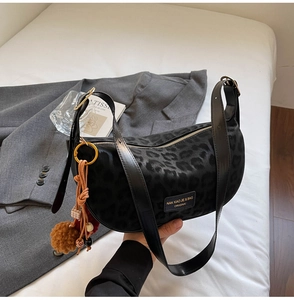 Détail de la texture velours léopard d'un sac avec un pendentif gland vintage