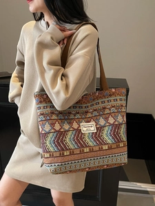 Ethnic style large tote bag with geometric patterns and shoulder strap shown on model