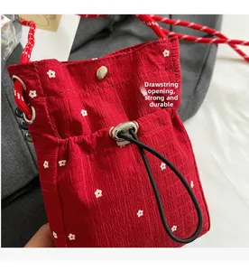 Detail view of red floral drawstring opening with durable woven rope strap and metal buckle