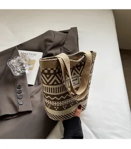 Detail of vintage canvas bucket bag with geometric patterns next to a blazer