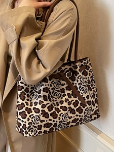 Large leopard and rose print tote bag with brown straps styled with a trench coat