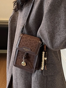 Brown leopard print crossbody phone bag with wooden beads on wool coat model
