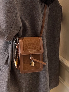 Brown leopard print crossbody phone bag with wooden bead charm on a grey wool coat