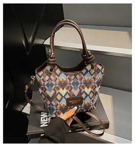 Detail of multi-color quilted jacquard bucket bag with knotted brown leather handle