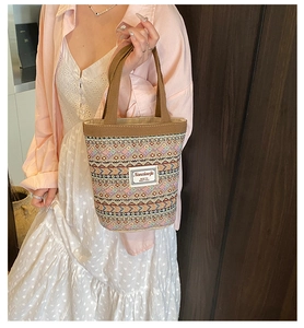 Vue détaillée du sac seau en lin avec motifs géométriques tissés colorés et poignée en tissu