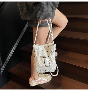 Quilted white bucket bag with bunny prints and black and white rope handle details
