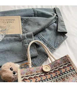 Detailed view of ethnic woven tote with cotton rope handles and plush charm detail