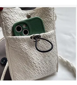 Detail of white woven PU leather phone bag with external pocket and metal snap button
