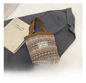 Détail des motifs tissés bohèmes et des poignées en toile marron d'un petit sac à main