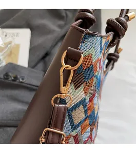 Detail of diamond pattern woven bucket bag with luxury gold hardware and leather knot