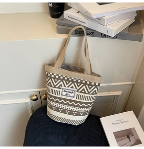 Close-up of geometric pattern canvas bucket bag with ethnic wave prints and a woven label