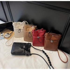 Close-up of trendy woven mini crossbody phone bags in five stylish colors with metal buckles