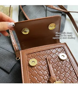 Detail view of brown woven leather crossbody bag featuring secure gold magnetic closure