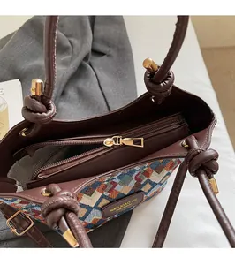 Macro view of geometric quilted tote bag showing smooth gold zipper and interior pocket