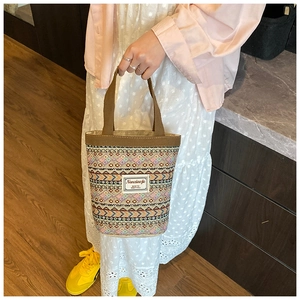 Détail du sac seau bohème avec des motifs géométriques tissés colorés et une poignée robuste