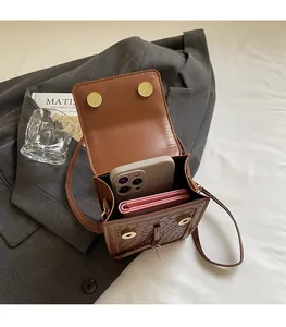 Detailed interior of brown woven crossbody bag showing space for phone and wallet