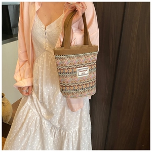 Détail d'un sac seau bohème en lin avec motifs colorés et poignées de couleur marron