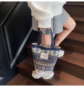 Detail of bohemian canvas bucket bag with ethnic elephant print and brand label on wood