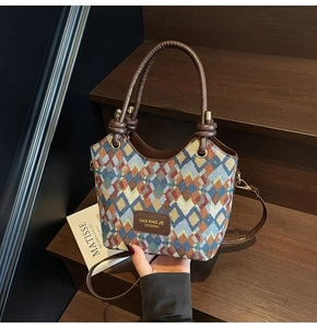 Detail of multi-color diamond lattice woven texture and brown leather knotted handle