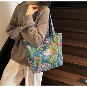 Detail of floral jacquard canvas tote bag with tropical leaf and butterfly patterns