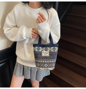 Detailed shot of ethnic print canvas bucket bag with elephant motifs and brand label