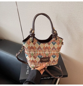 Detail of multi-color diamond lattice woven bucket bag with brown leather knotted handle