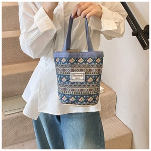 Détail du sac seau en lin avec motifs géométriques ethniques et bandoulière bleue