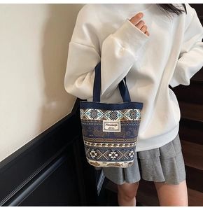 Detailed view of bohemian canvas bucket bag with ethnic elephant jacquard and fabric label