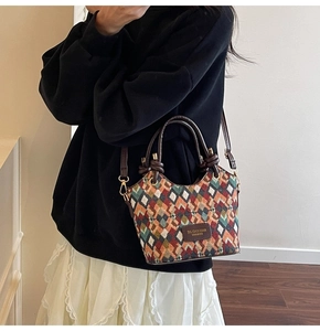 Close-up of geometric quilted bucket bag with colorful woven texture and leather strap