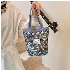 Détail du sac seau en lin avec motifs géométriques colorés et poignée en tissu