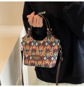 Detail of multi-color woven bucket bag with quilted patterns and leather handle