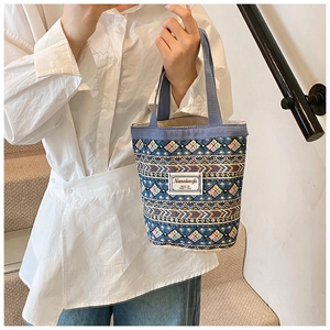 Gros plan détaillé d'un sac seau en lin bleu avec motifs tissés ethniques
