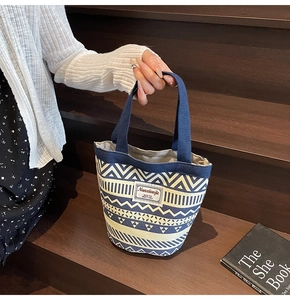 Detail of canvas bucket bag with ethnic geometric pattern and blue sturdy handles