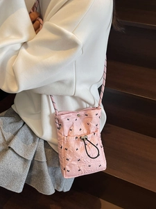 Stylish pink quilted crossbody phone bag with drawstring pocket and braided strap
