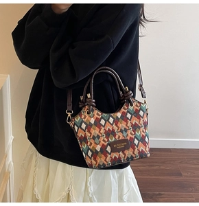Detailed view of colorful quilted bucket bag with leather handles and textile texture