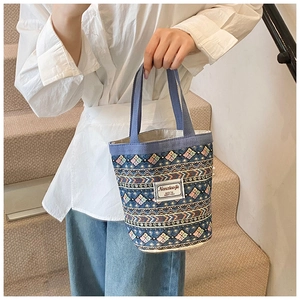 Détail d'un sac seau en lin bleu ethnique avec motifs colorés et double poignée