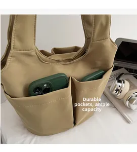 Dettaglio della borsa a secchiello kaki con tasche esterne e ampia capacità interna
