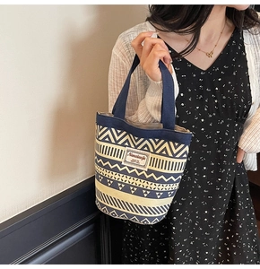 Ethnic style canvas tote bag featuring geometric patterns worn by a model in a casual setting