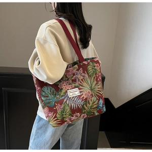Detail shot of vintage jacquard floral tote bag showing fabric texture and sturdy red handles