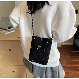 Detail of floral crossbody bag with metal snap button and slim dual-tone cord strap