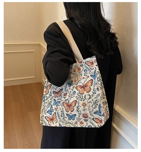 Detailed macro view of the jacquard fabric texture and vintage butterfly pattern on this tote bag